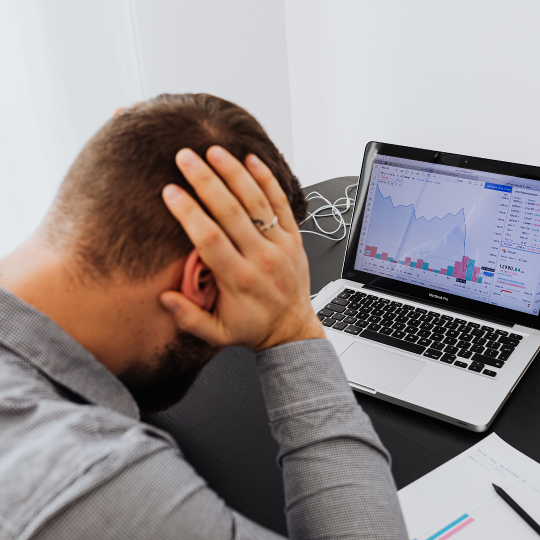 An adult man having trouble prioritizing tasks in the office