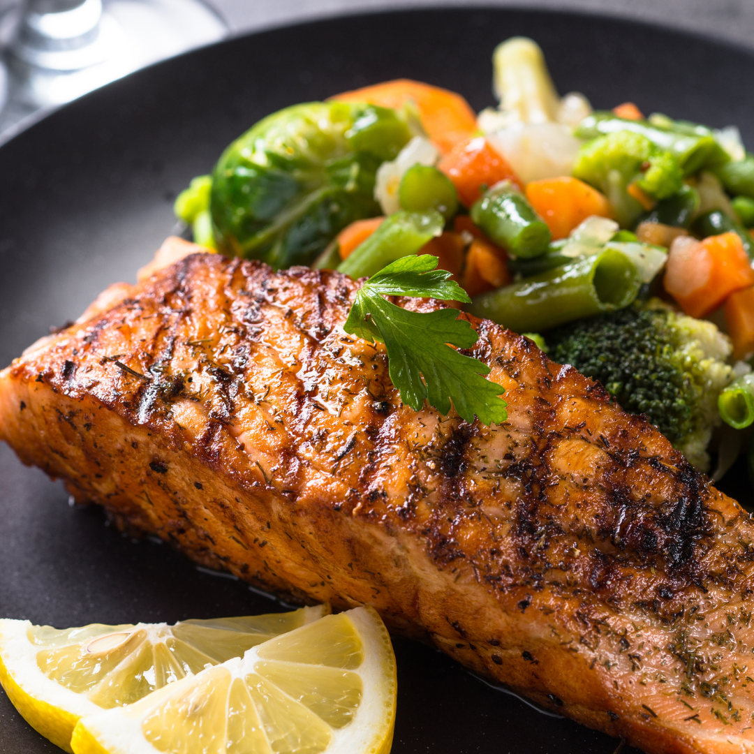 Heart-healthy meal of baked salmon and roasted vegetables prepared using One Wellness Center nutrition guidance