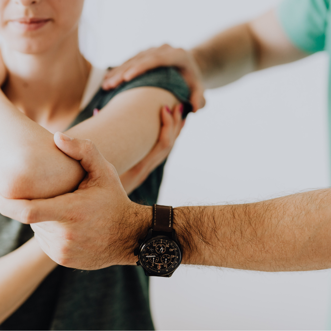 A clinician or an expert helping the patient exercise her joints